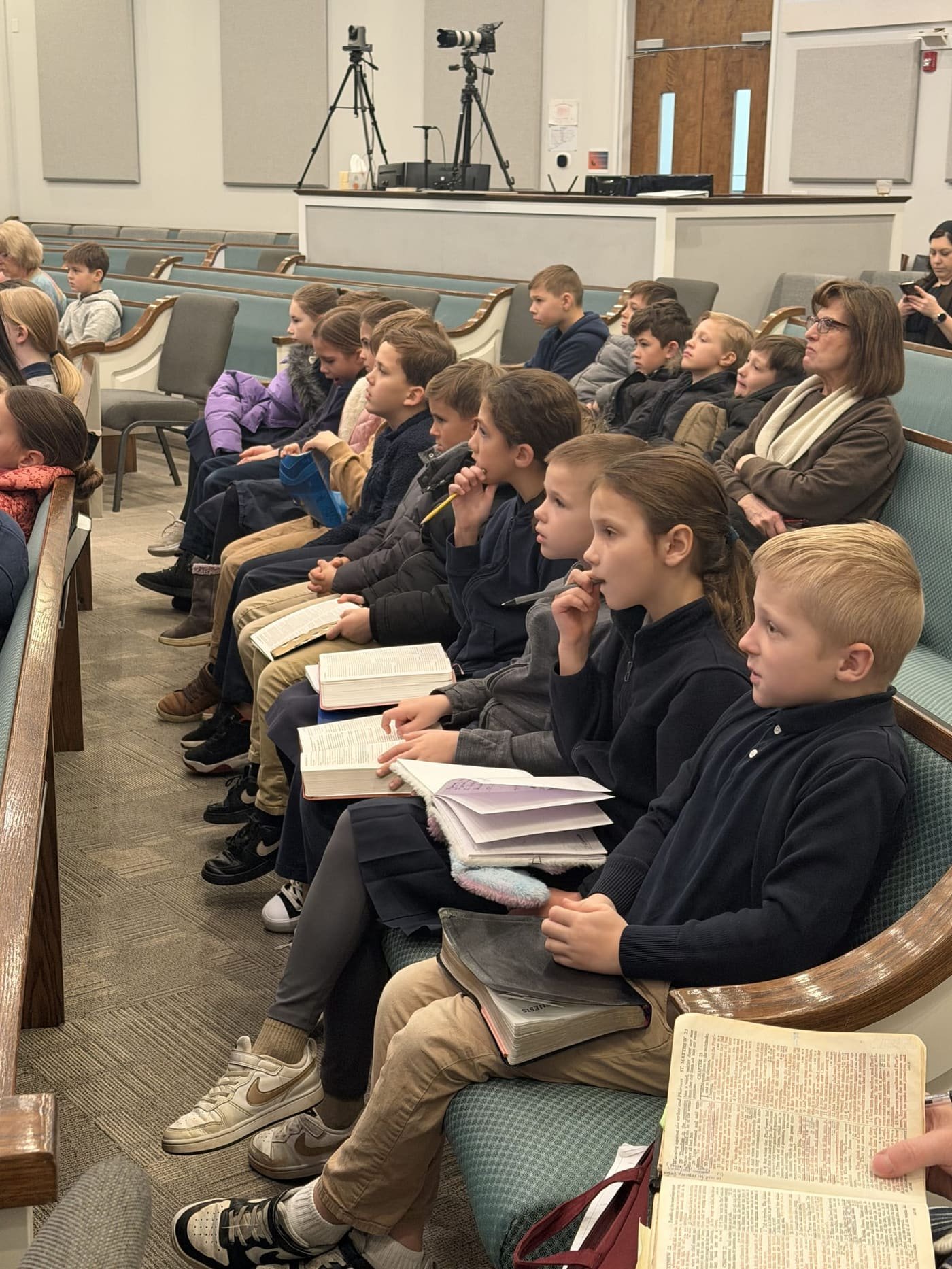 Students with open Bibles during chapel or Scripture study at Gospel Light Academy