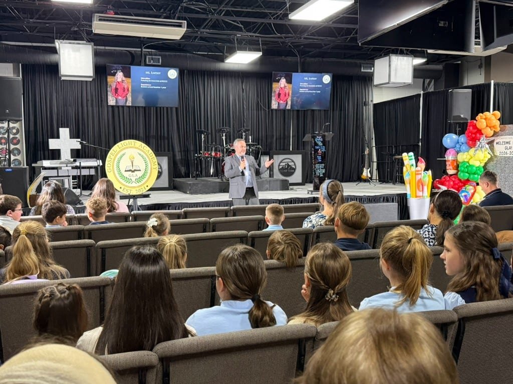 Students seated in chapel as a speaker addresses Gospel Light Academy from the stage