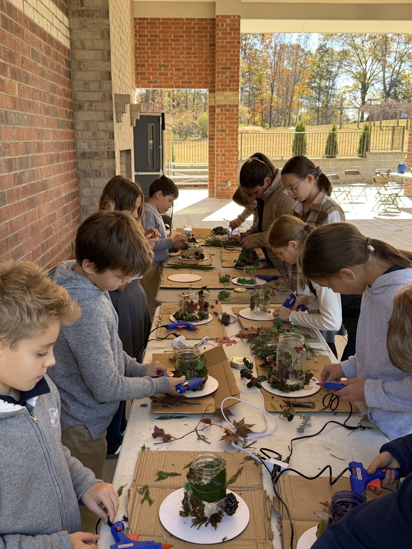 Students making nature crafts together outdoors at Gospel Light Academy